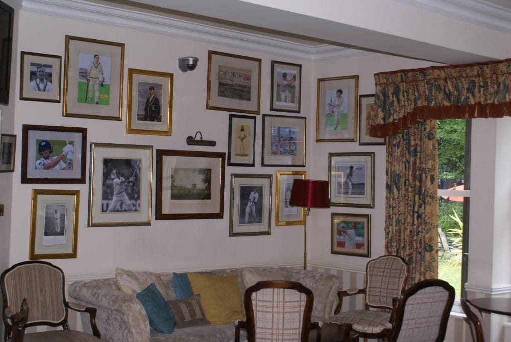 Una sala de estar con un sofá, sillas y una pared decorada con cuadros.
