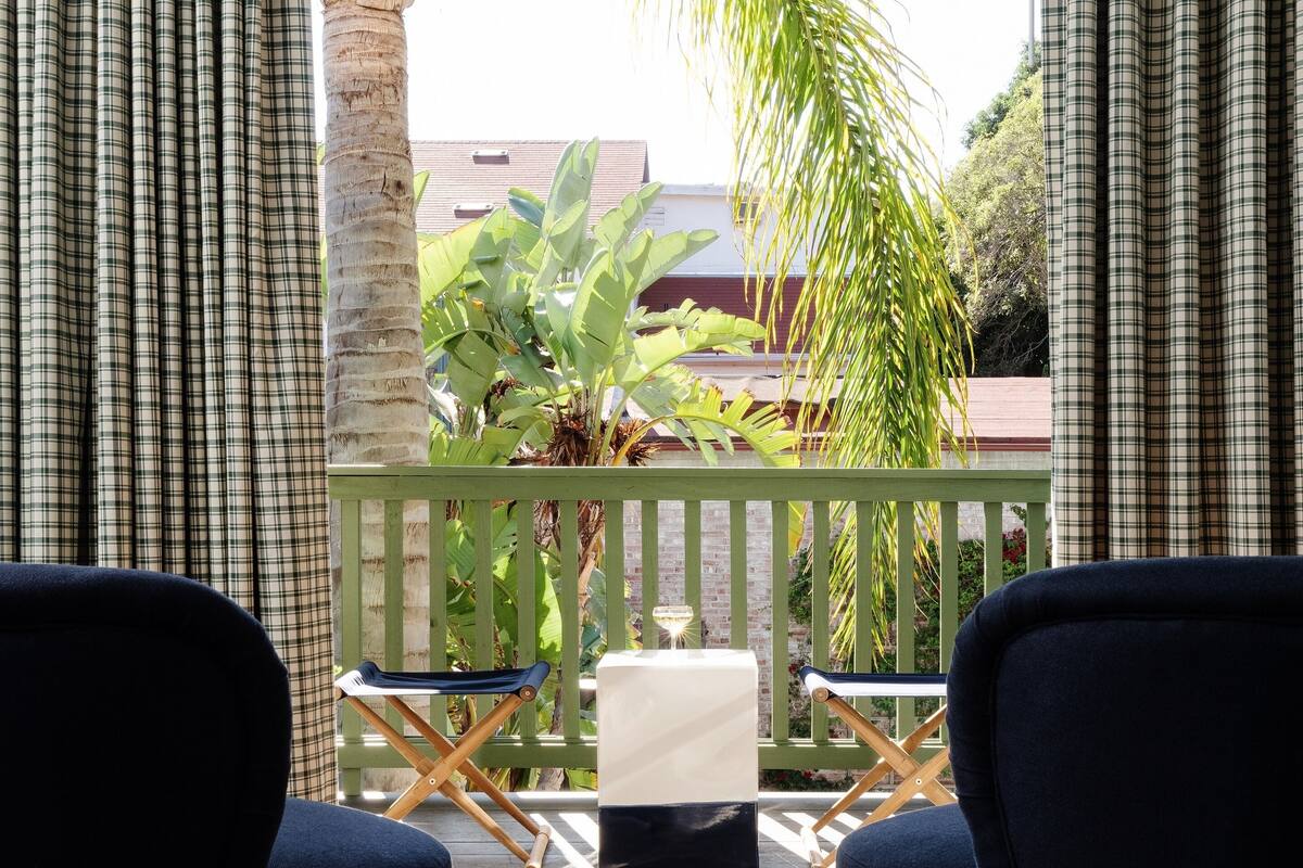 Ein Balkon mit zwei Stühlen, einem kleinen Tisch und einem Blumentopf.