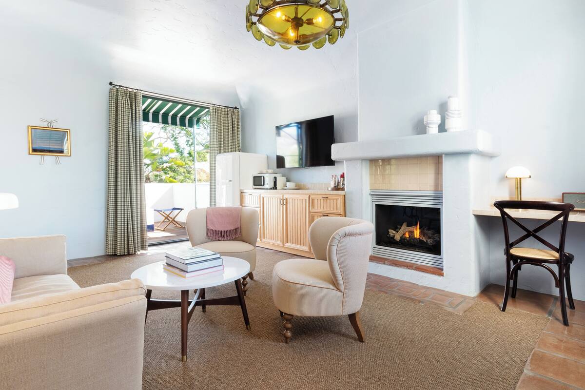 Ein Wohnzimmer mit Kamin, Fernseher und Küchenzeile.