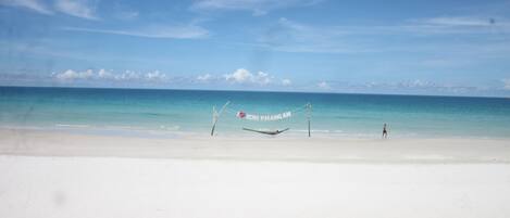 Una playa con una hamaca y un letrero que dice 'I love Koh Phangan'.