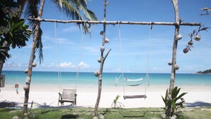 A beach with a swing set, a hammock, and a bench. - Tommy Resort (Ko Pha-ngan)