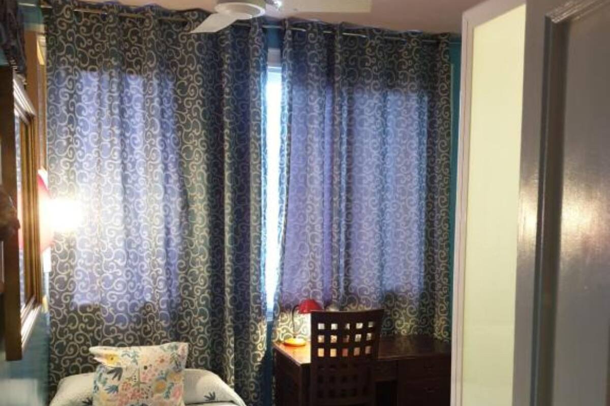 A hotel room with a bed, a desk, and a chair.