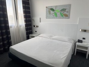 A hotel room with a large bed, a bedside table with a phone, and a wall-mounted artwork. - B&B HOTEL Milano Cologno Sporting (Cologno Monzese)