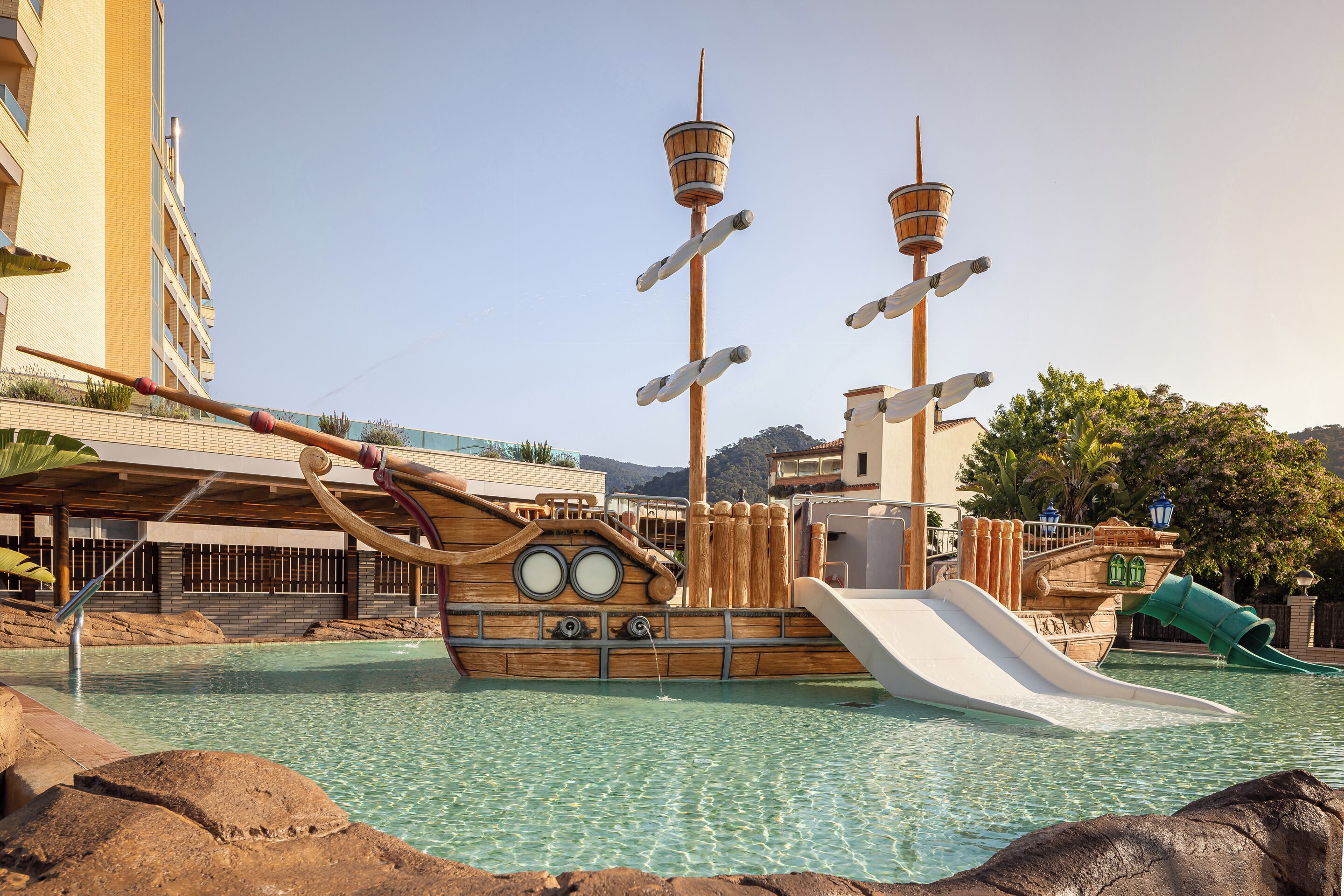 Een piratengezond waterpark met een schipvormige glijbaan en een hoge torenstructuur.