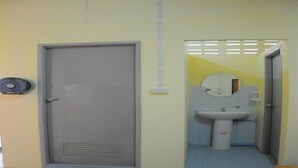 Une salle de bain avec un lavabo, un miroir et une porte.