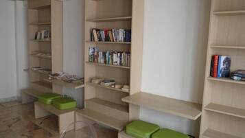 Una biblioteca con scaffali multipli e contenitori verdi.