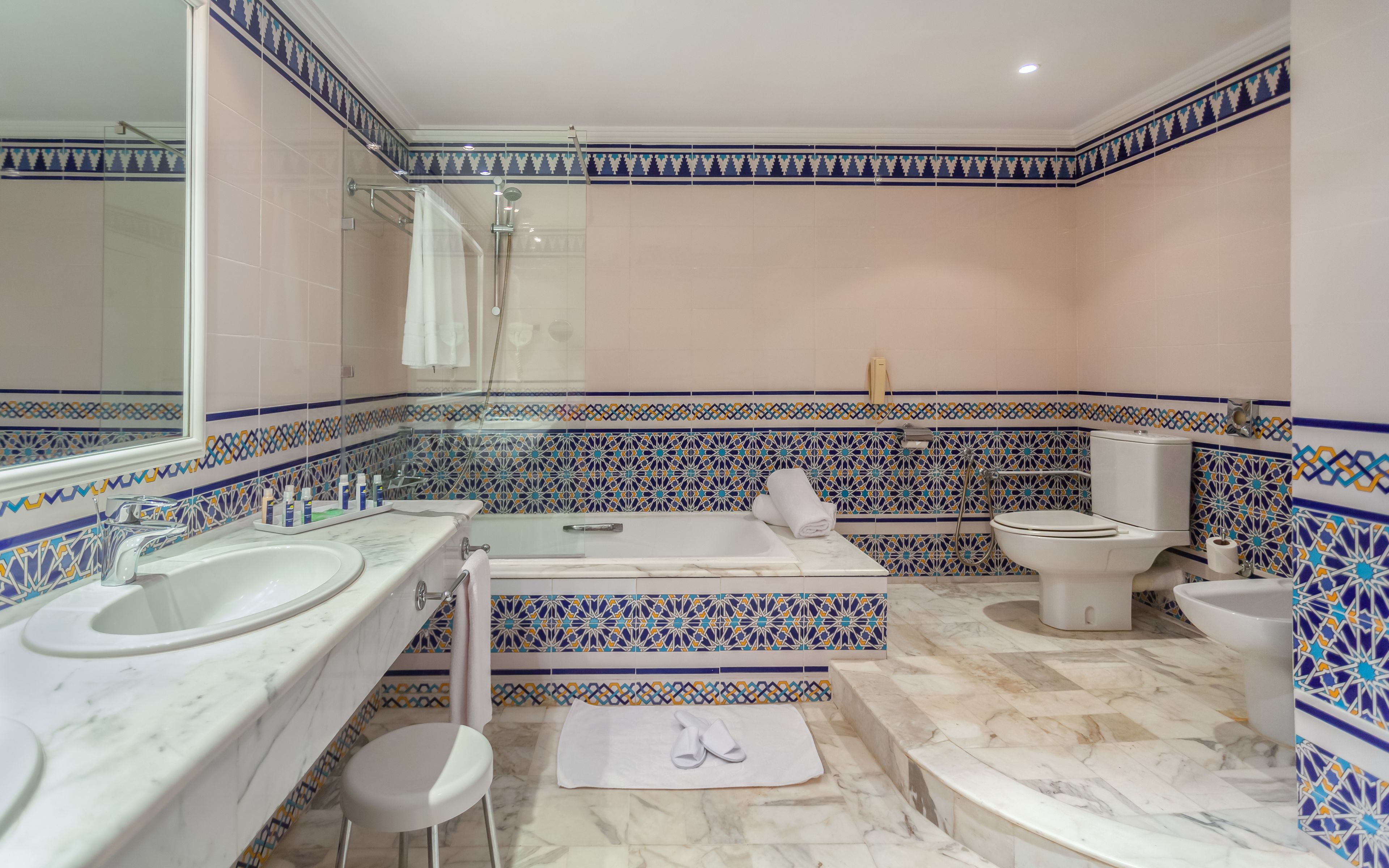 Un baño con dos lavamanos, una bañera y un inodoro.