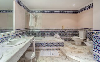 Un baño con dos lavamanos, una bañera y un inodoro.