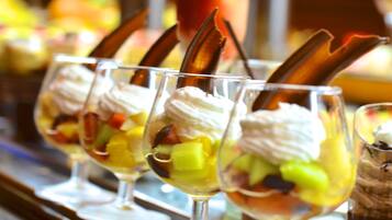 A dessert bar with various ice cream sundaes in glasses.