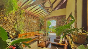 Un rincón interior acogedor con muebles de madera y un fondo de pared de piedra.