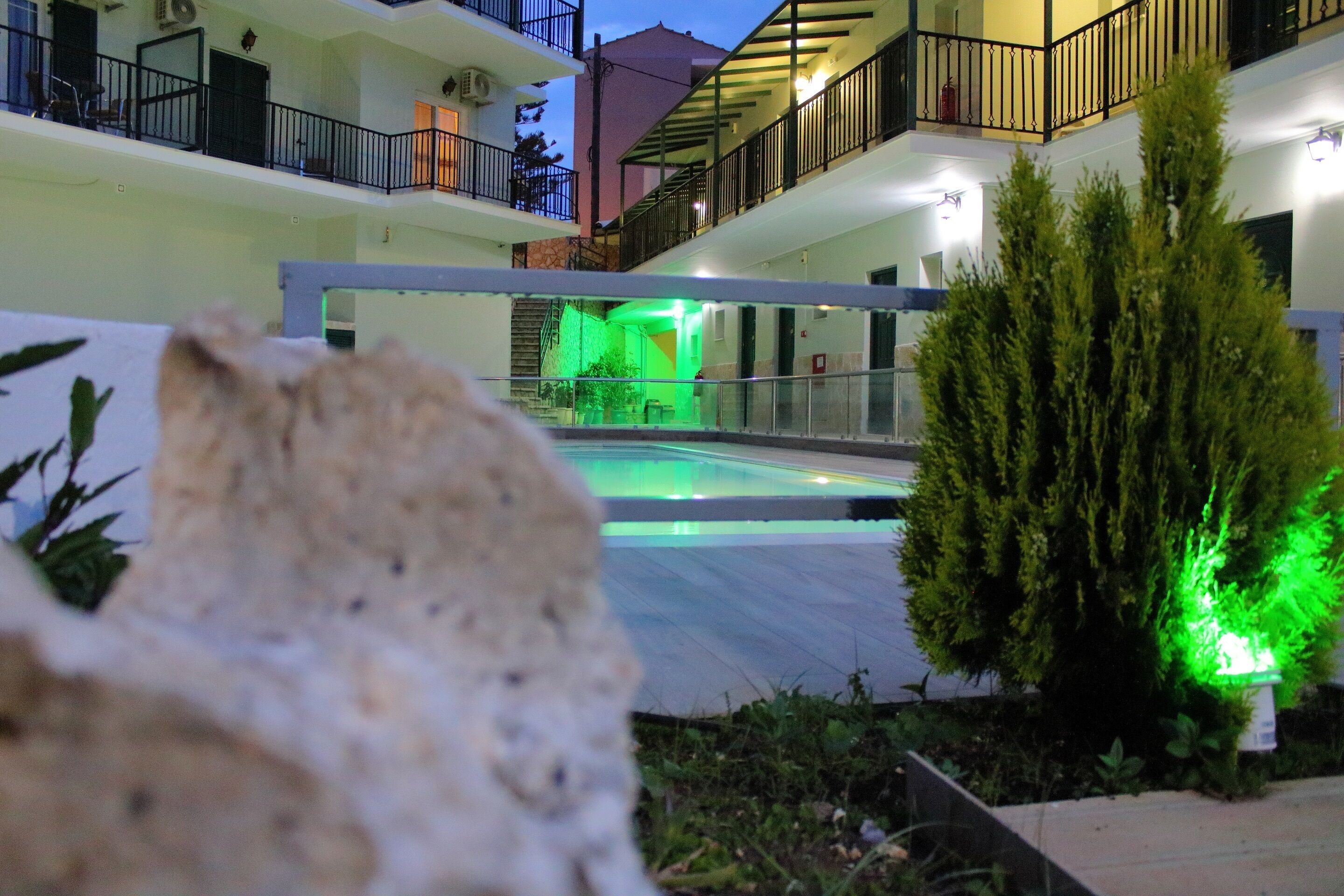 A courtyard with a pool, surrounded by buildings with balconies and railings.