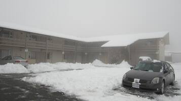 Un edificio con varios pisos y balcones, rodeado de nieve.