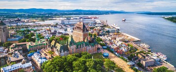 Une vue urbaine mettant en valeur un bâtiment historique remarquable, une rivière et un pont.