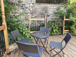 Relax on the patio with a glass-top table and two comfortable chairs.