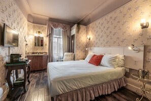Relax in a stylish room with a large bed, comfortable seating area, and a kitchenette.