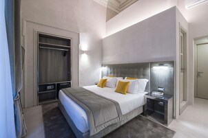 Una camera d'hotel moderna con un letto grande, comodini, un armadio e una cabina armadio.