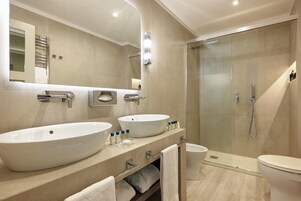 Un bagno moderno con due lavandini, una cabina doccia in vetro e un water.