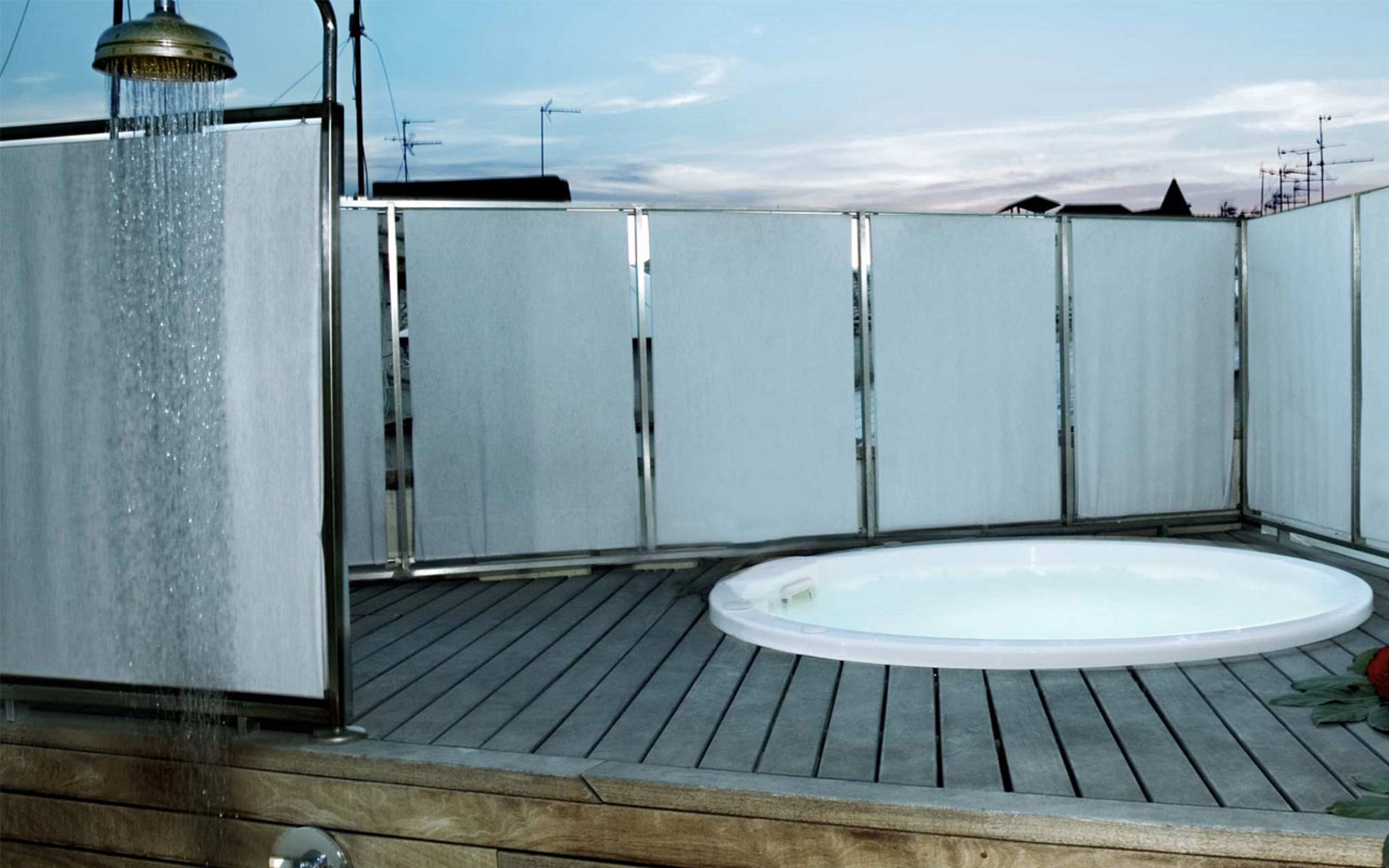 Un jacuzzi en una terraza de madera con un elemento acuático.