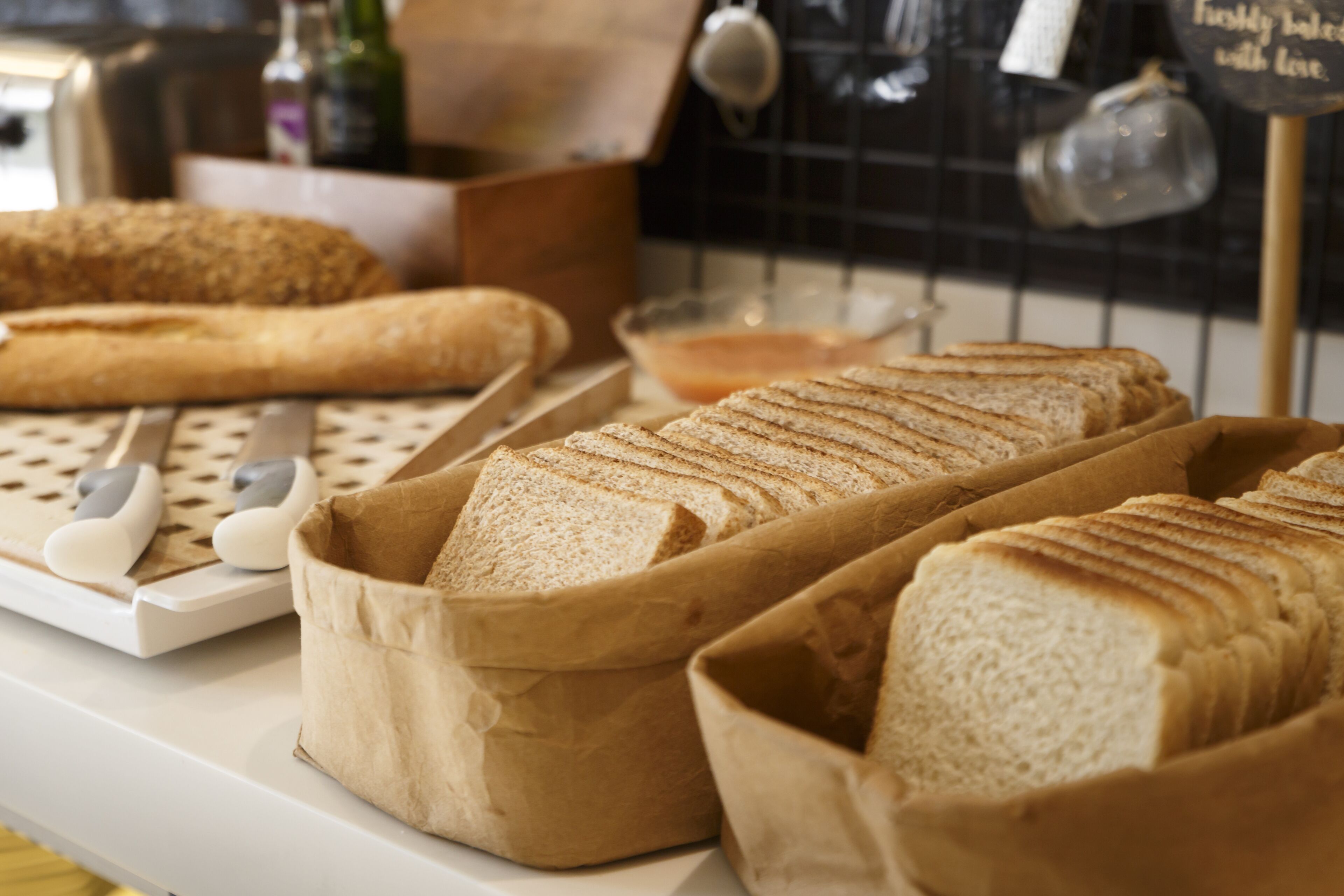 Mostrador de panadería con hogazas de pan y un cortador de pan.