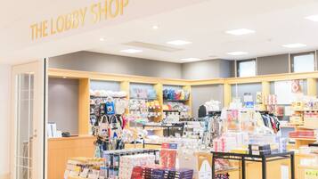 A store named "THE LOBBY SHOP" with shelves of bags, accessories, and food items.