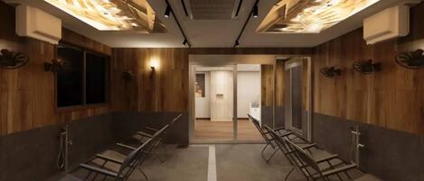 A modern restroom with wooden paneling, metal benches, and recessed lighting.