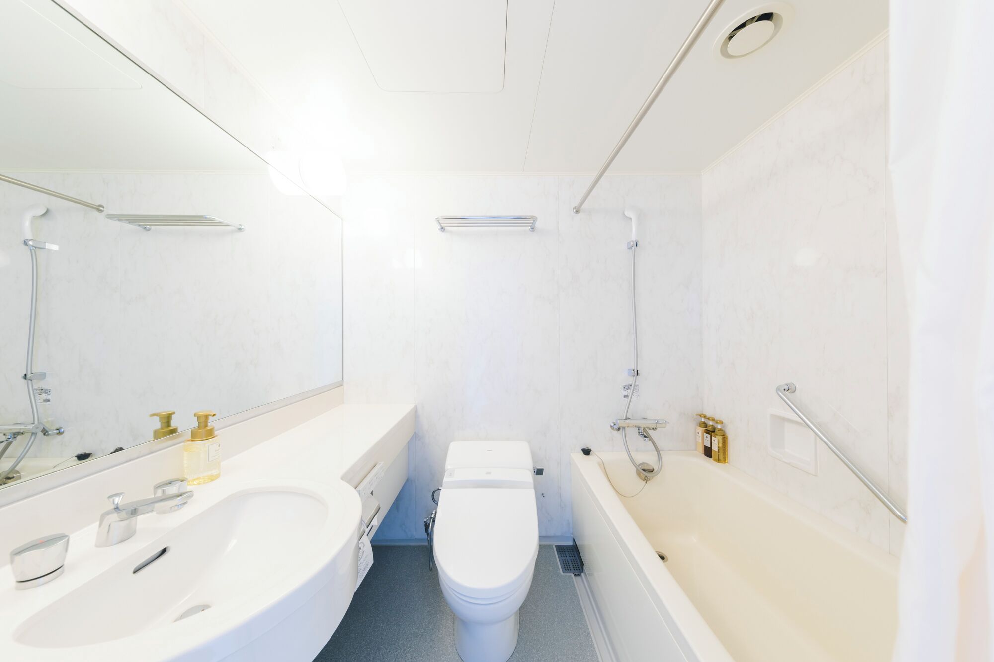 A modern bathroom with a white sink, toilet, and bathtub.