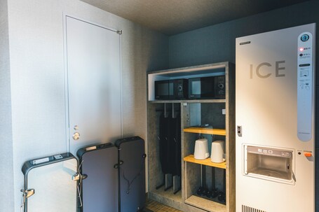 A compact hotel room with a minibar, a microwave, and an ice dispenser.