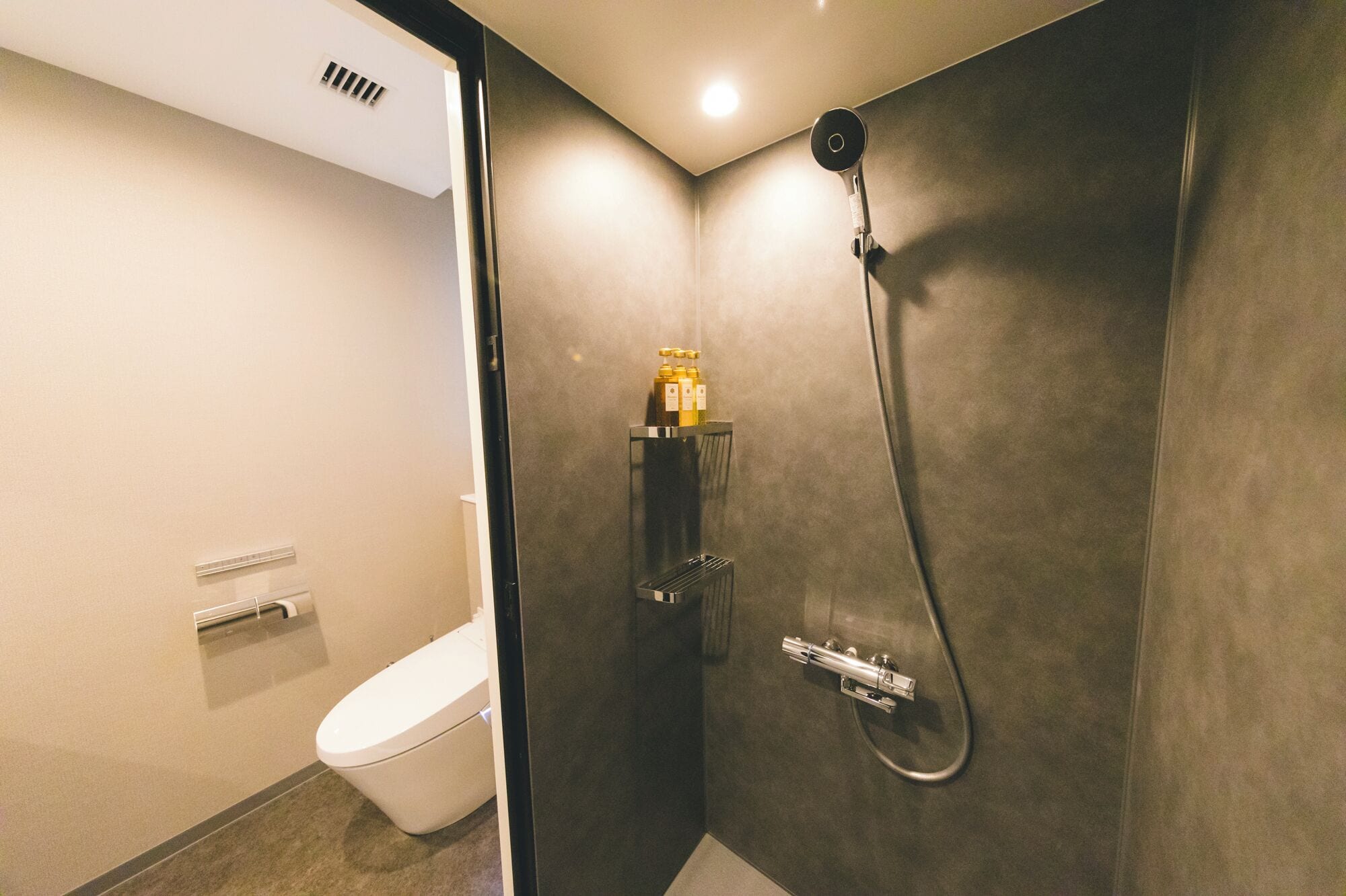 Un baño moderno con ducha, inodoro y barra para toallas.