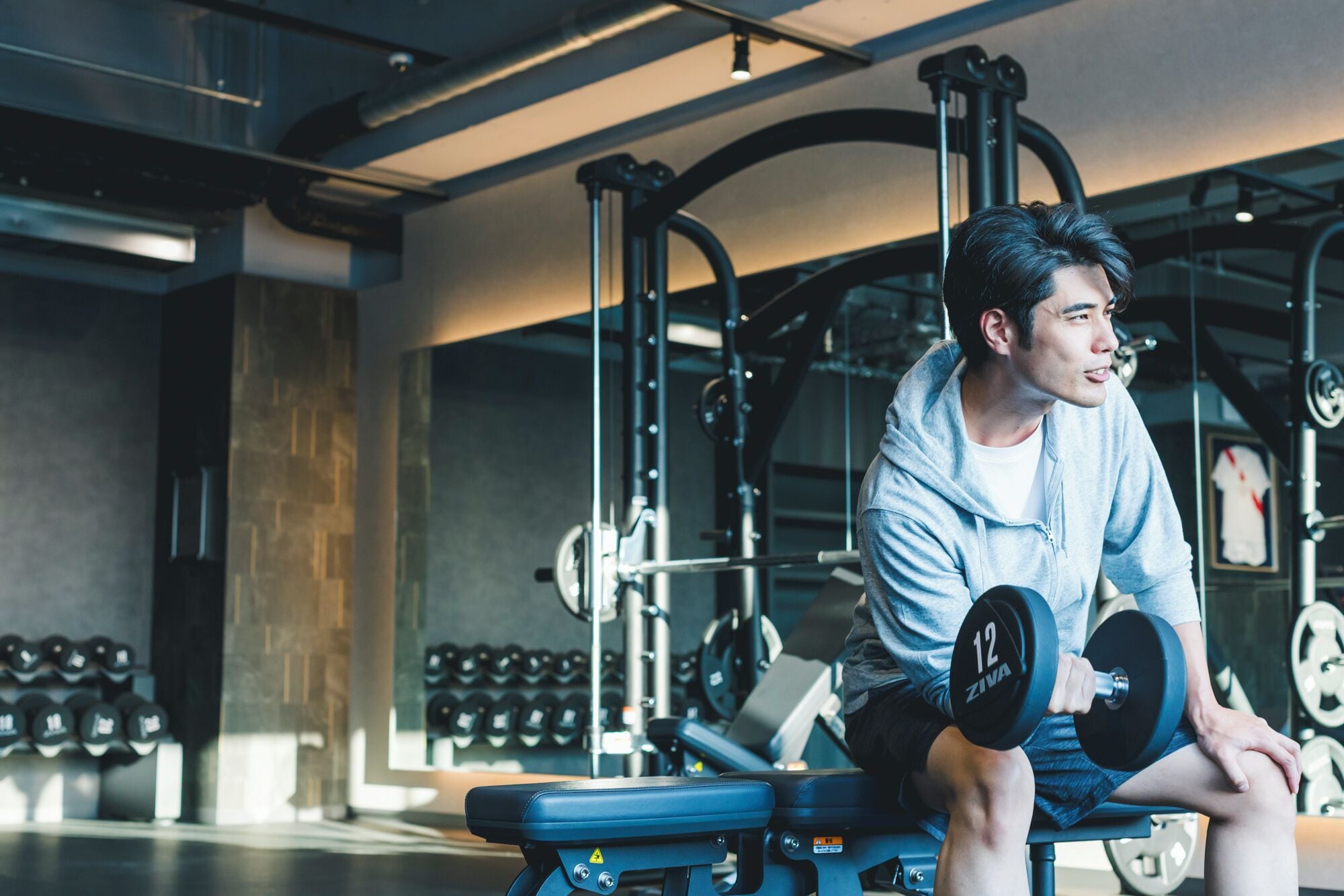 A gym with weightlifting equipment, benches, and dumbbells.
