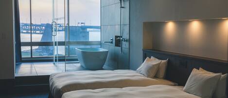 Habitación de hotel moderna con una cama grande, una bañera y cabina de ducha de vidrio.