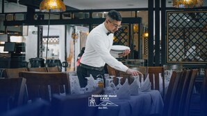 Un restaurante con un camarero sirviendo platos.