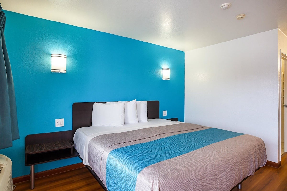 Ein Hotelzimmer mit einem Bett, einer Sitzbank und zwei Wandleuchten.