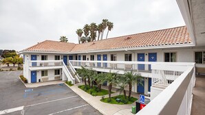Un motel composé d’un bâtiment à deux étages, de plusieurs chambres et d’un espace de stationnement.