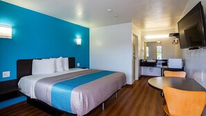 Une chambre d’hôtel avec un lit, un bureau et une télévision.