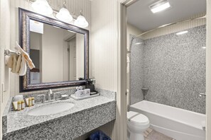 Bathroom features a granite countertop, sink, coffee maker, toilet, bathtub, and shower.