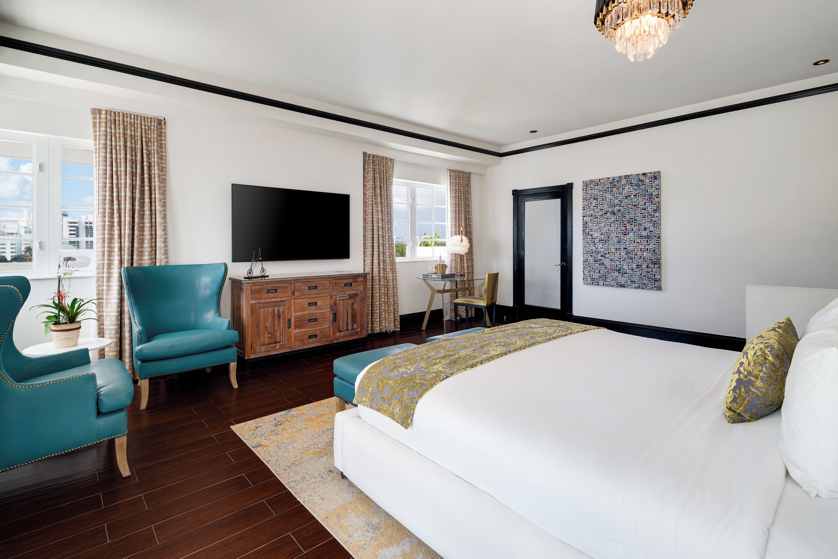Habitación de hotel moderna con una cama grande, un televisor de pantalla plana, un aparador de madera y vistas a la ciudad.