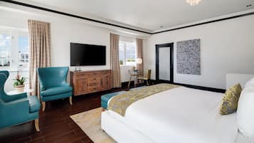 Habitación de hotel moderna con una cama grande, un televisor de pantalla plana, un aparador de madera y vistas a la ciudad.
