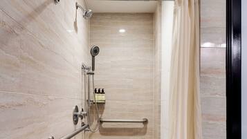 A modern shower with a handheld showerhead, a built-in seat, and a towel rack.