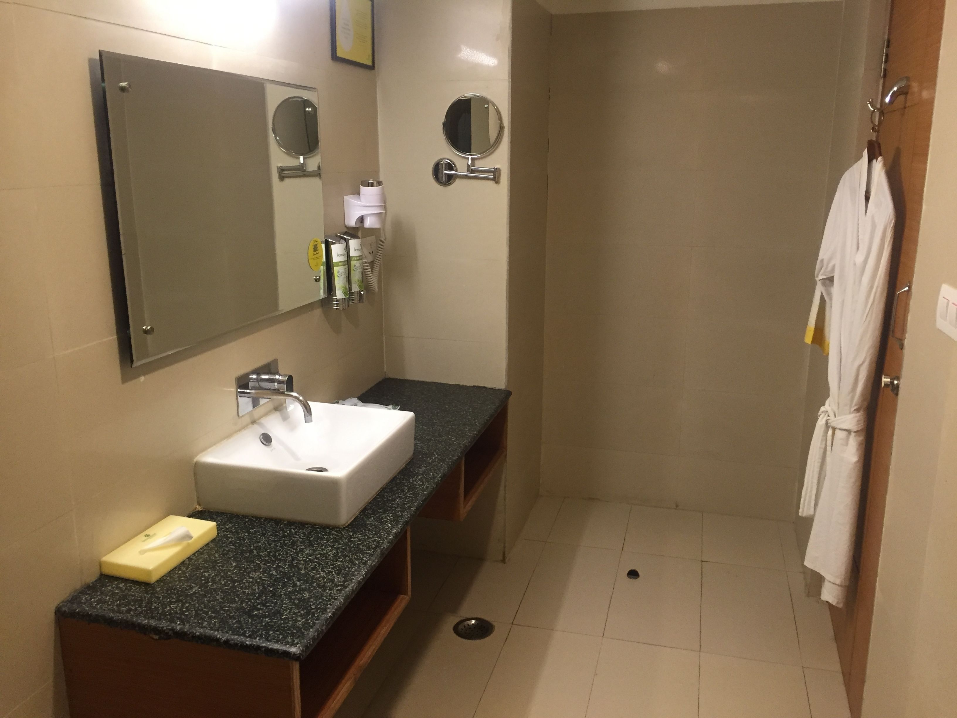 A bathroom with a sink, mirror, and shower.