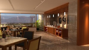 Un intérieur moderne comprenant un coin repas, une cuisine et de grandes fenêtres offrant une vue sur les montagnes.