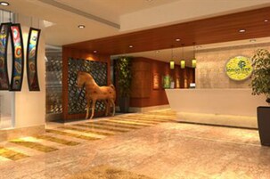 A reception area with a wooden reception desk, a horse sculpture, and a logo on the wall.
