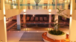A hotel lobby with a pool, seating area, and a reception desk. - Aranwa Paracas Resort & Spa (Paracas)