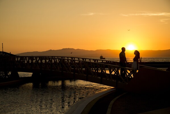 Atardecer sobre un puente con dos personas de pie.