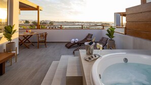 A rooftop terrace with a hot tub, lounge chairs, a table with drinks, and a city view. - Aranwa Paracas Resort & Spa (Paracas)