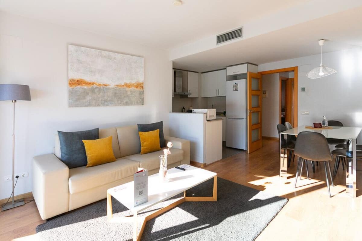 Una sala de estar moderna con sofá, mesa de centro y comedor.
