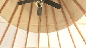 Un intérieur chaleureux avec un lit, une table et un ventilateur de plafond.