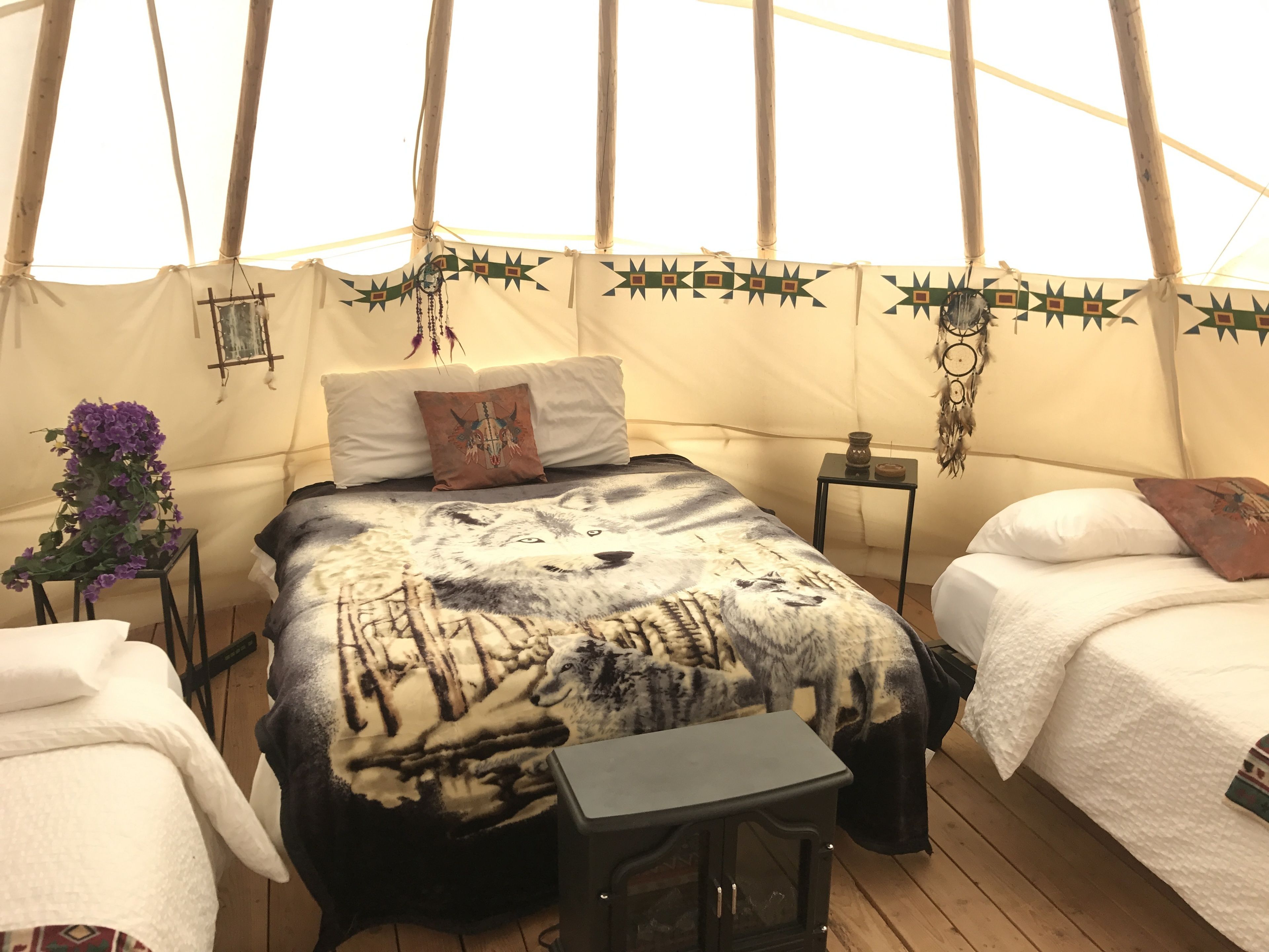 A tented room with a bed, a small table, and a nightstand.