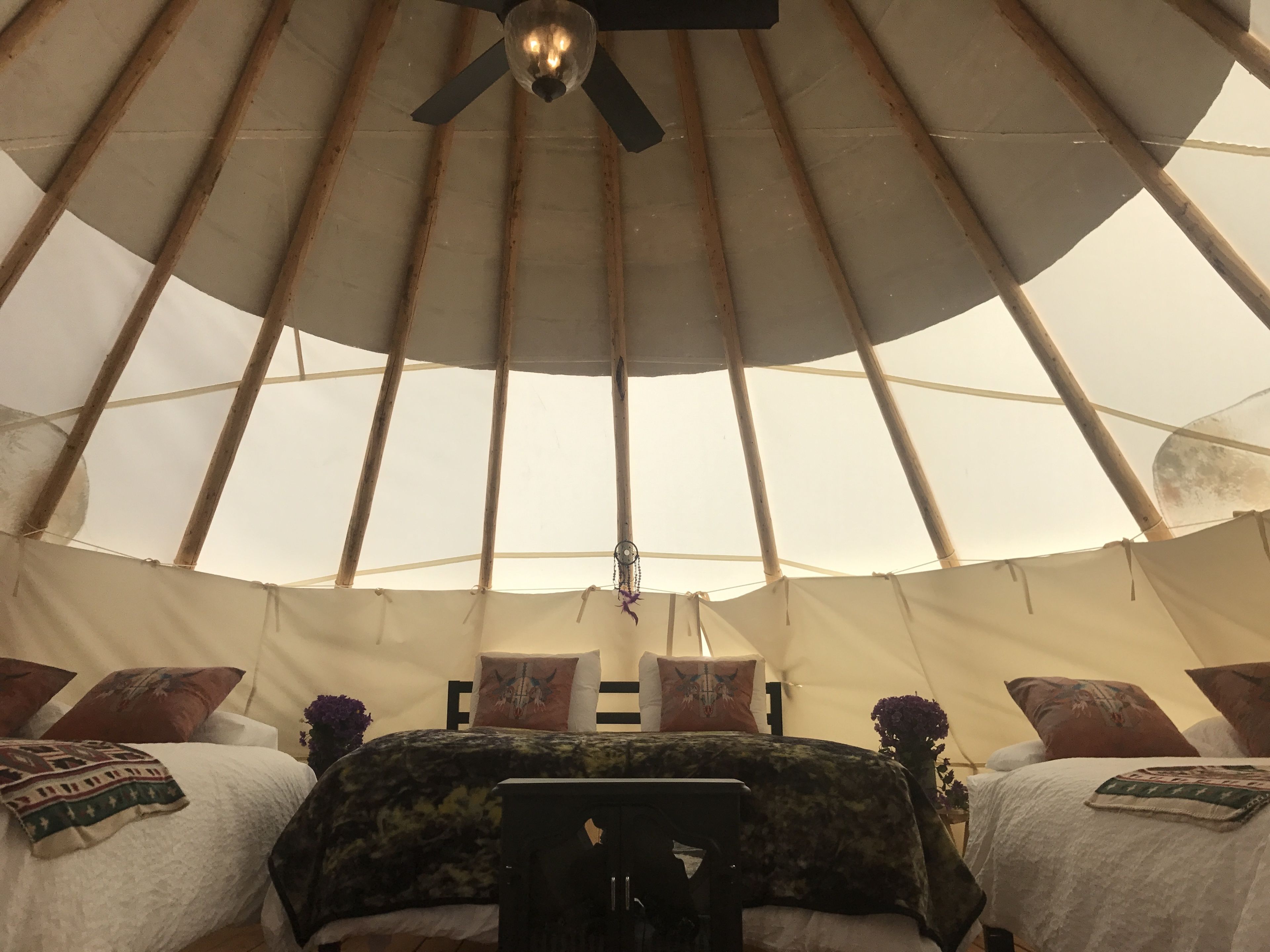 Ein gemütliches Interieur mit einem Bett, Kissen und einem Deckenventilator.