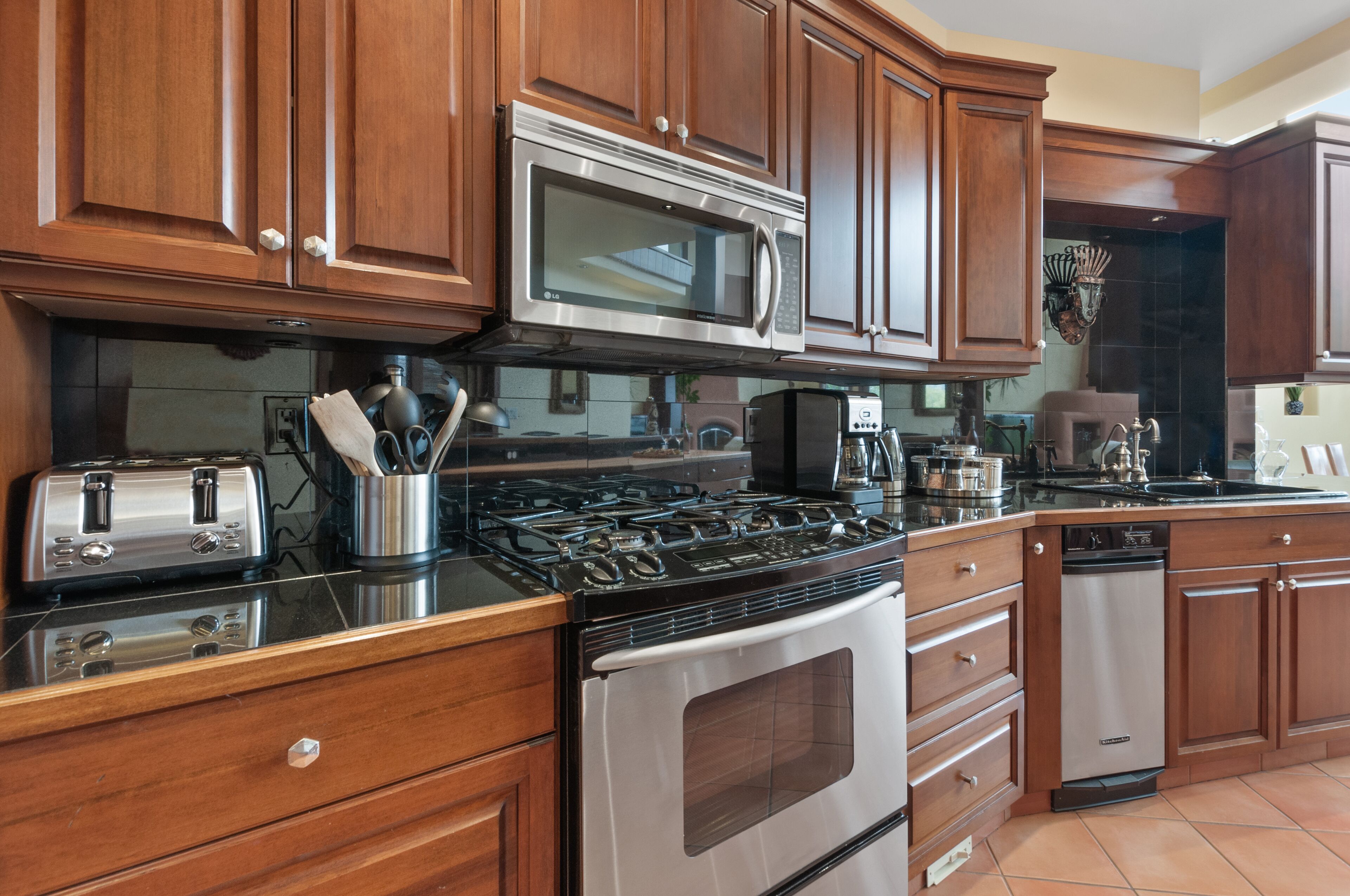 A kitchen with wooden cabinets, stainless steel appliances, a gas stove, a microwave, and a dishwasher.