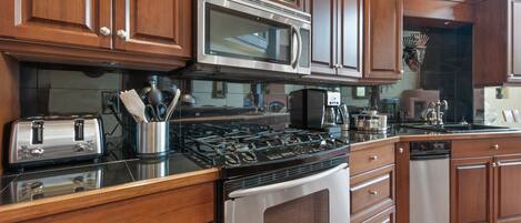 A kitchen with wooden cabinets, stainless steel appliances, a gas stove, a microwave, and a dishwasher.